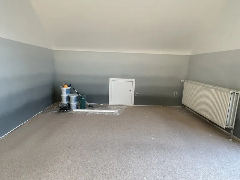 Zimmer mit zweifarbiger Wandaufteilung in Grau und Weiß