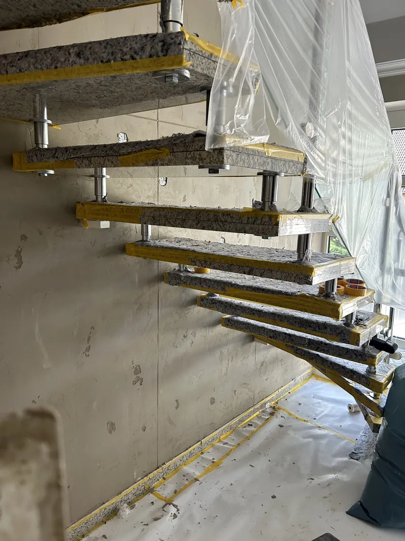 Freitragende Treppe abgeklebt, die Wand wird gespachtelt