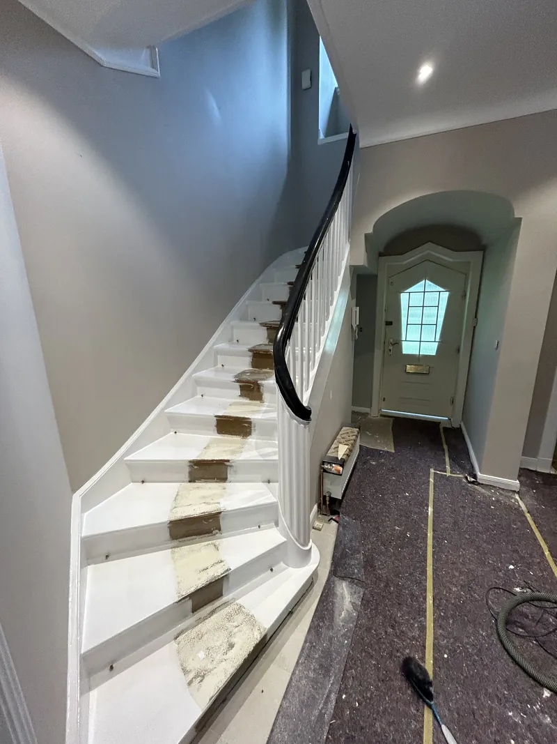 Treppenhaus mit weißer Treppe und hellblau abgesetzter Wand