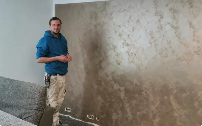 Lennert Kock vor einer Wand in Spachteltechnik